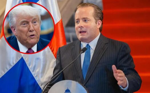 Sprecher bei Pressekonferrenz und Bild von Donald Trump ist eingeblendet